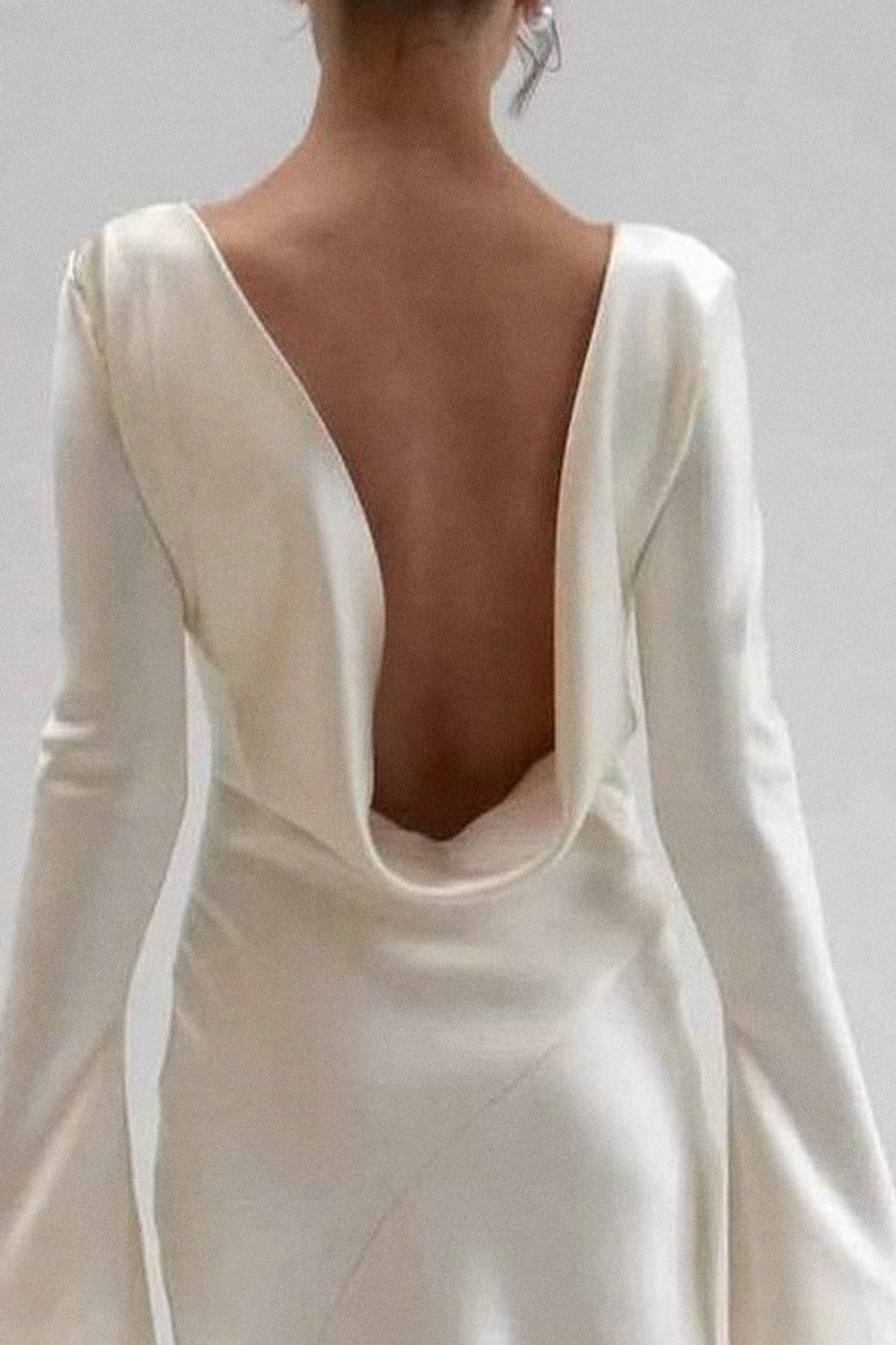 Close-up of the deep scooped cowl open back on the ivory satin maxi dress