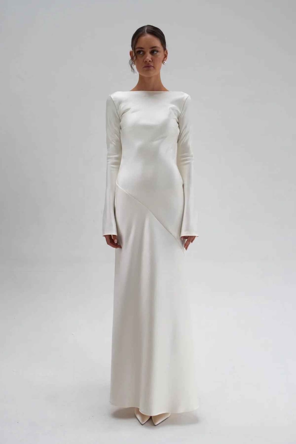 Full-length studio front view showing the diagonal bias seam across the hip of the satin maxi dress