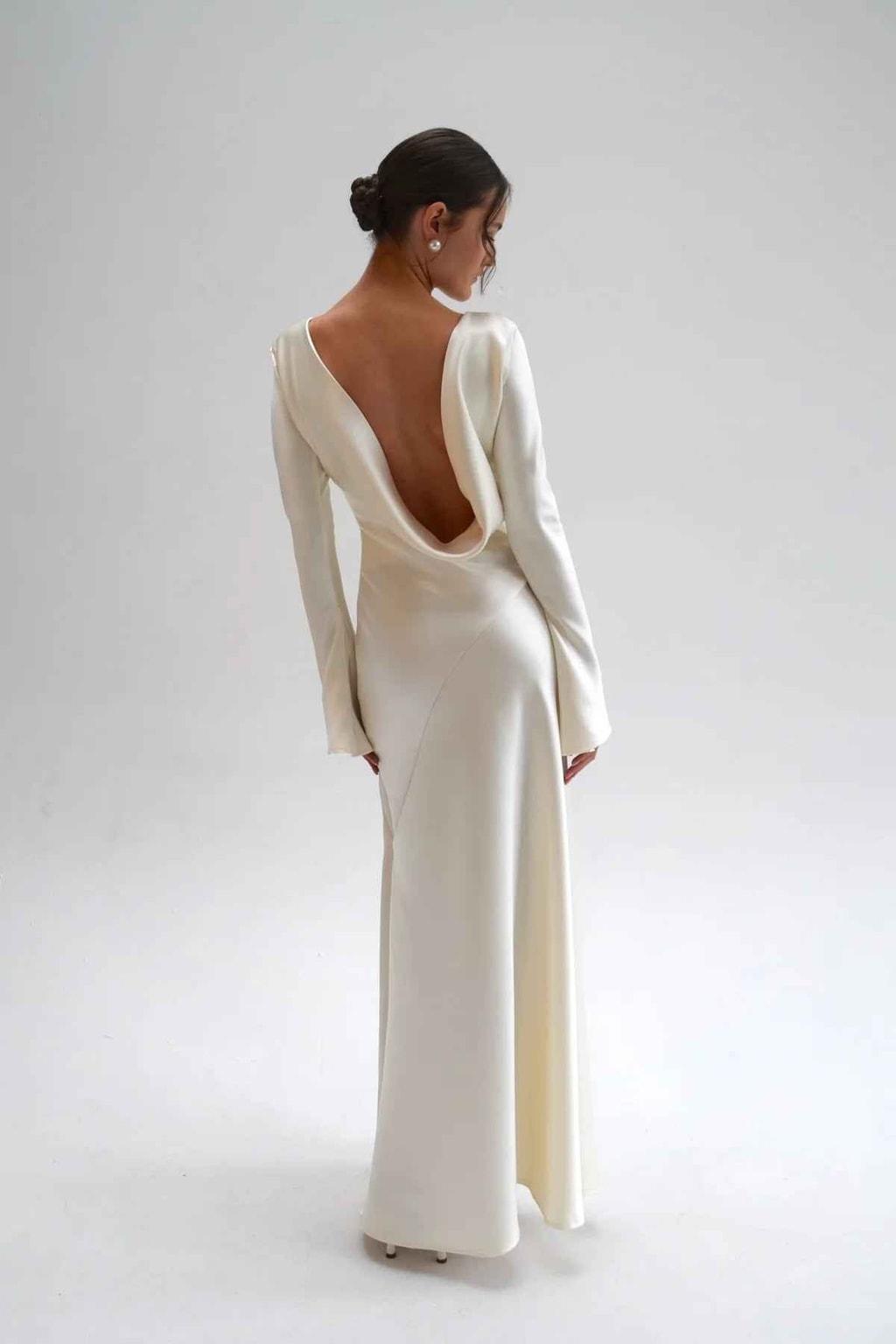 Angled back view showing the cowl drape and bias-cut seams across the ivory satin skirt