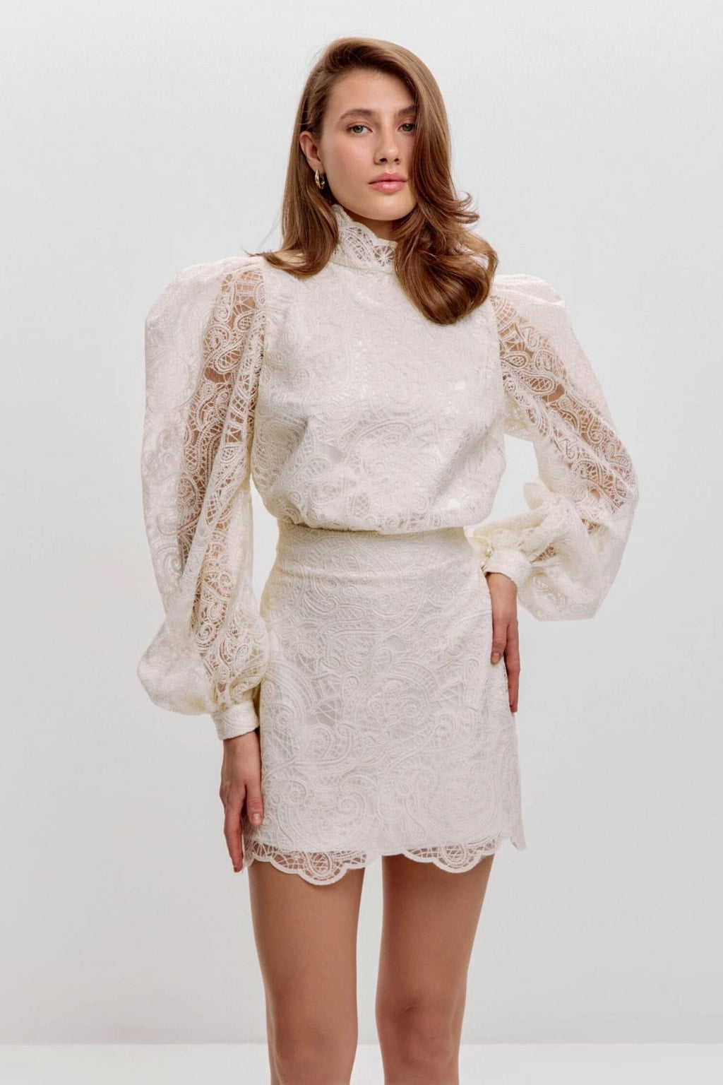 Front view of the ivory lace two-piece set showing the structured puff shoulders and mock neck