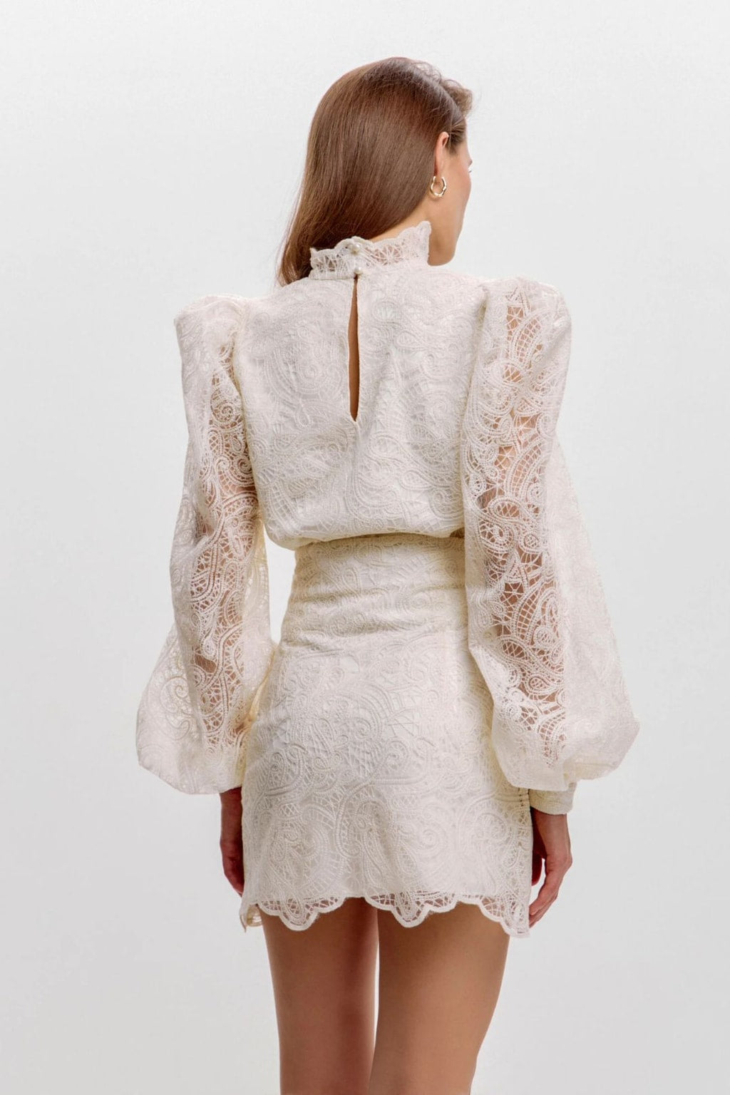 Back view showing the blouse hem falling over the skirt waistband and the scalloped lace hem