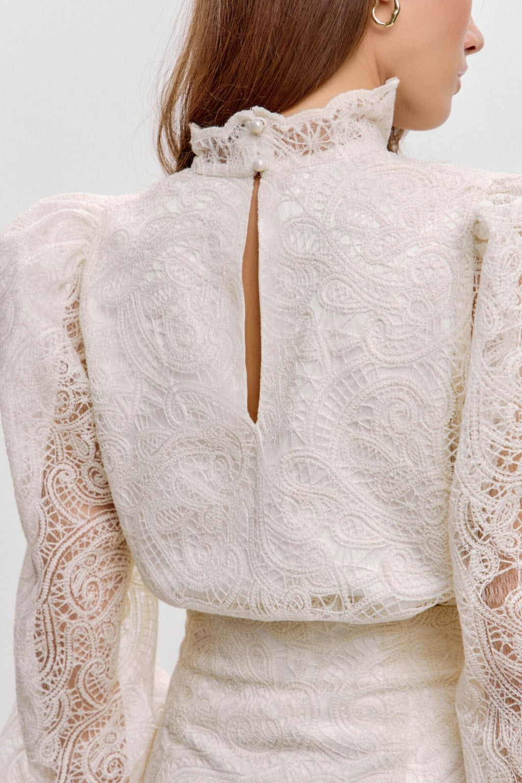 Close-up of the keyhole back neck with pearl buttons on the ivory lace blouse