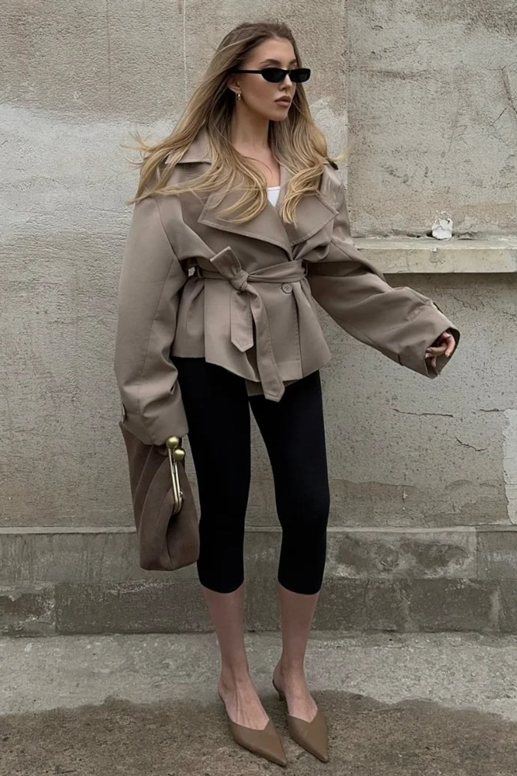 Beige cropped trench jacket that wraps across the front with a self-tie belt, epaulettes and buttoned cuff tabs