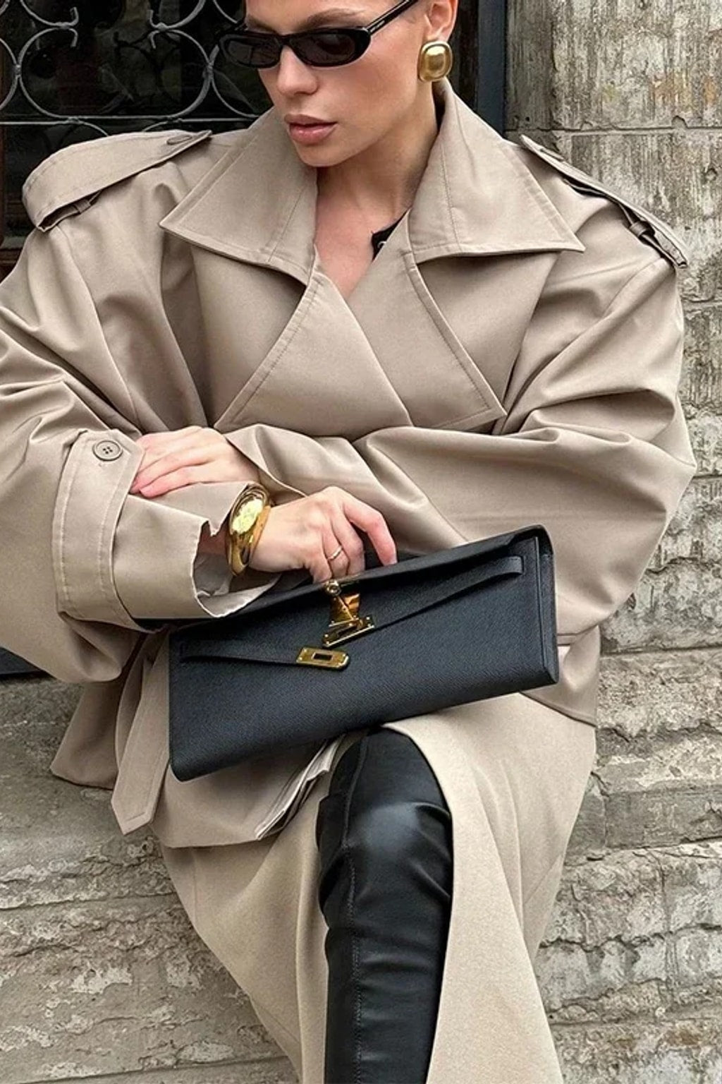 Beige cropped trench jacket that wraps across the front with a self-tie belt, epaulettes and buttoned cuff tabs