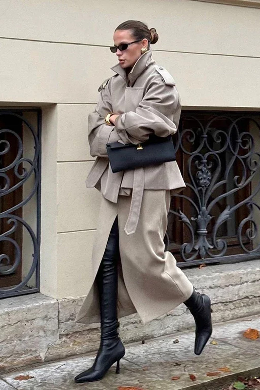 Beige cropped trench jacket that wraps across the front with a self-tie belt, epaulettes and buttoned cuff tabs