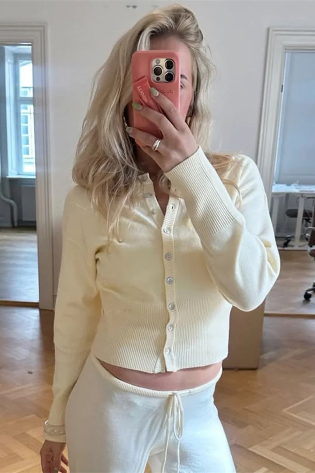 Pink cropped knit cardigan with a scalloped button placket and a deep ribbed waistband