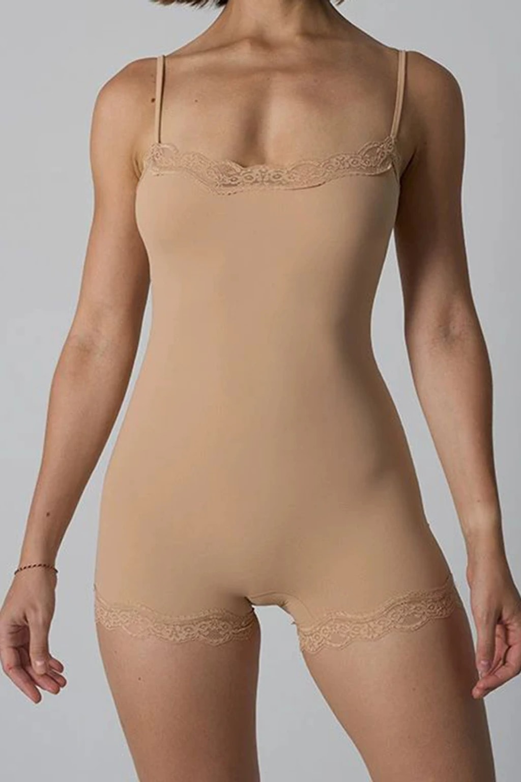 Pink ribbed knit playsuit with scalloped lace trim at the neckline and leg openings and adjustable straps