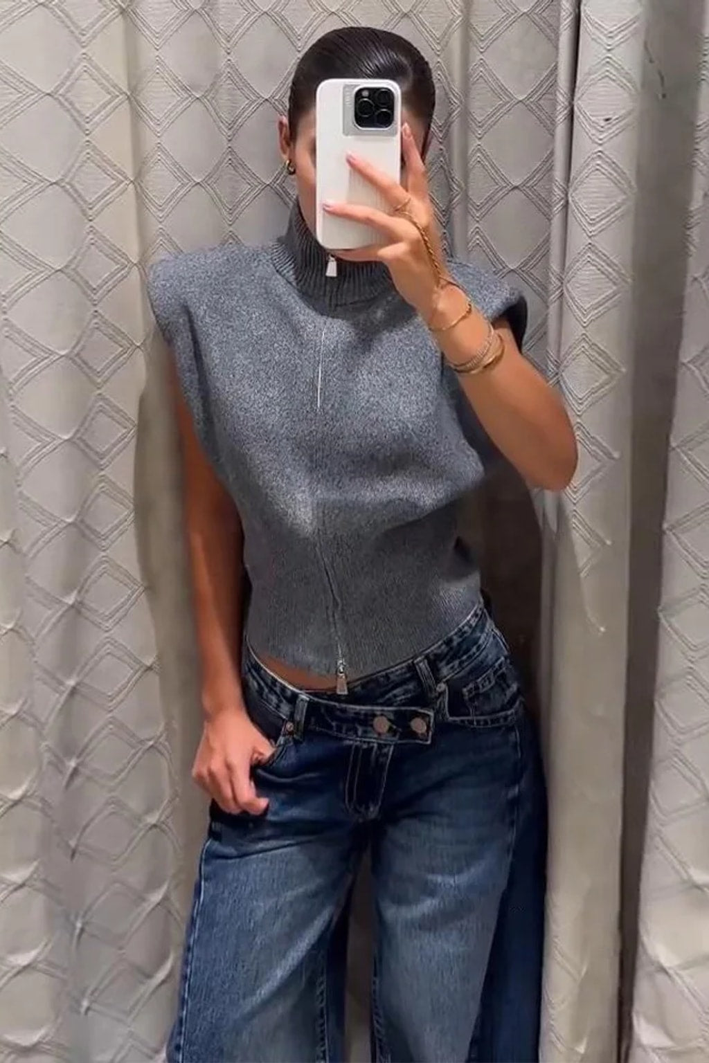 Grey fitted sleeveless knit vest with a high ribbed funnel neck, two-way front zip and structured shoulders