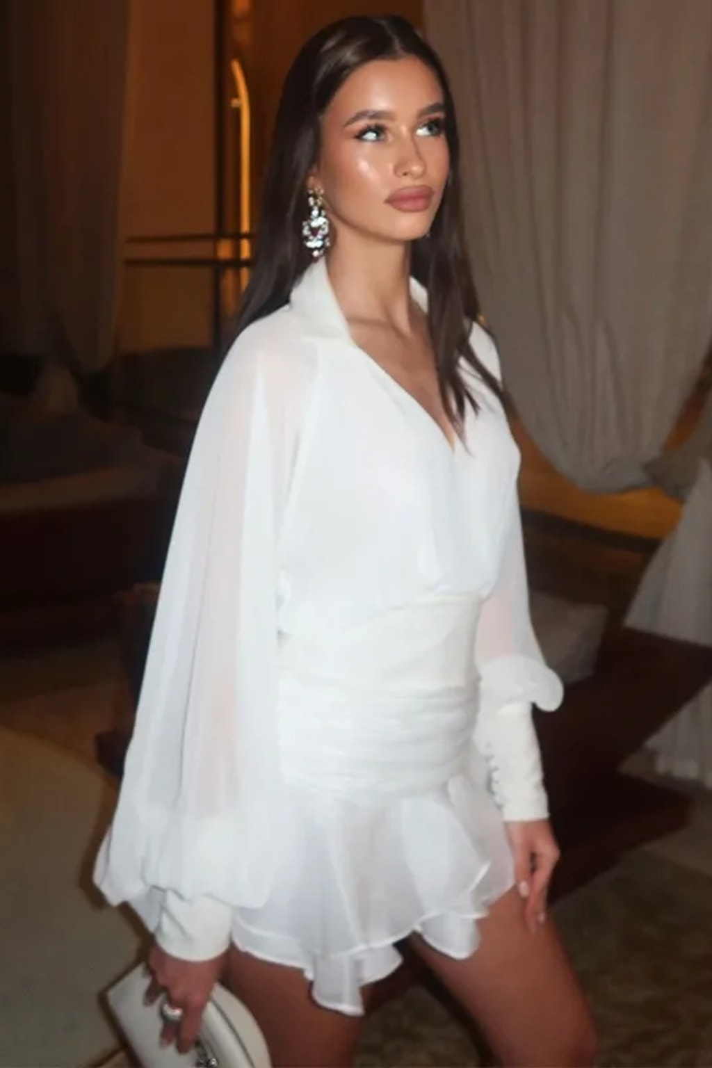 White two-piece set with an open-back chiffon blouse with balloon sleeves and a ruched-waist ruffle mini skirt
