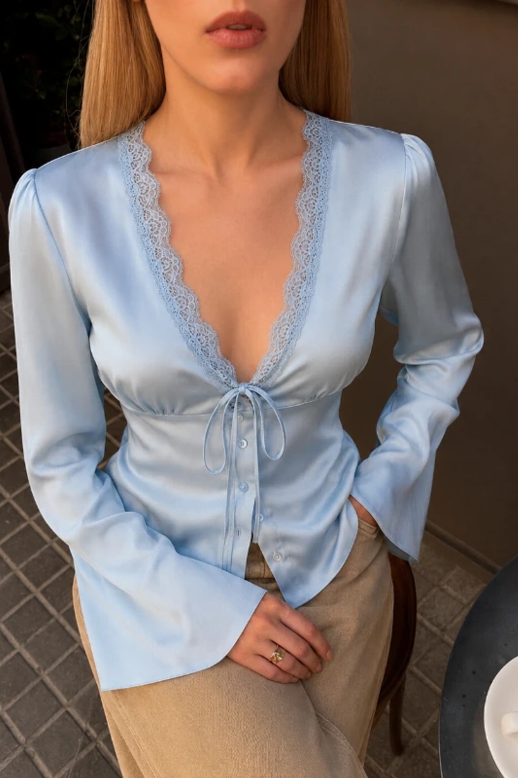 Satin blouse with scalloped lace at the deep V neckline, a tie bow and wide flared bell cuffs