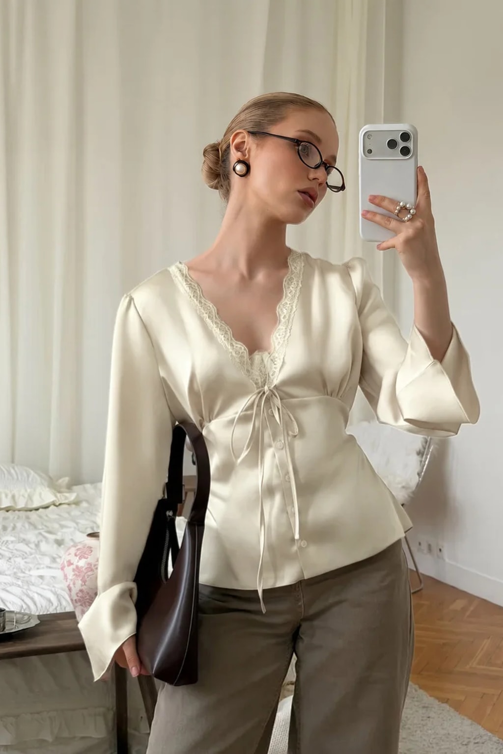 Satin blouse with scalloped lace at the deep V neckline, a tie bow and wide flared bell cuffs