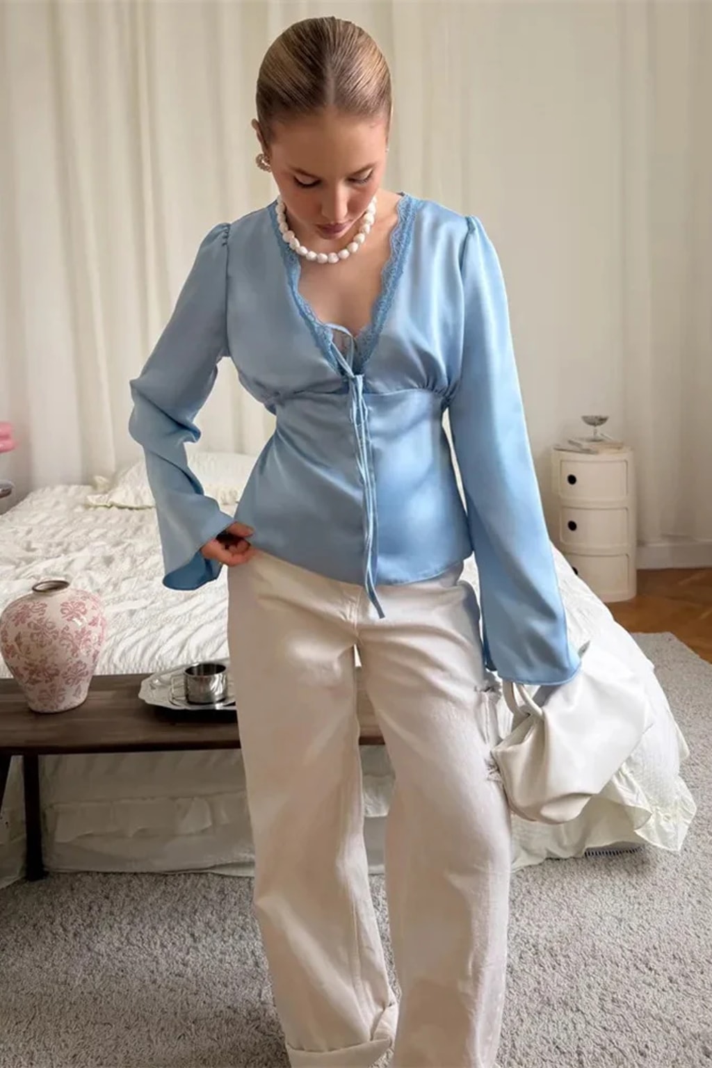 Satin blouse with scalloped lace at the deep V neckline, a tie bow and wide flared bell cuffs