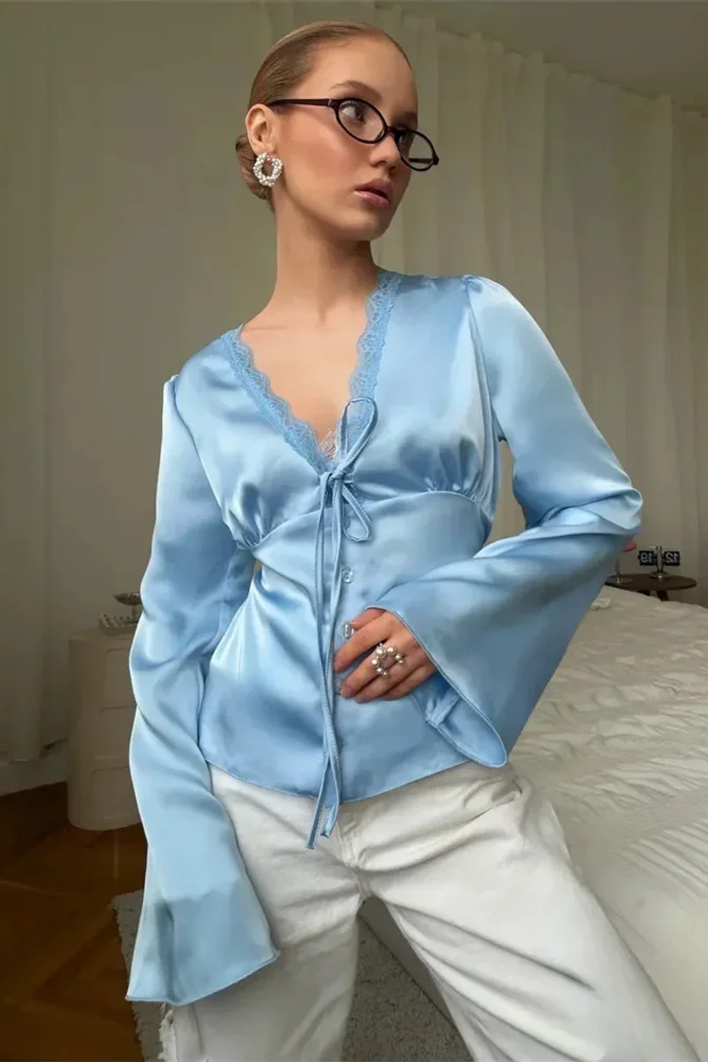 Satin blouse with scalloped lace at the deep V neckline, a tie bow and wide flared bell cuffs
