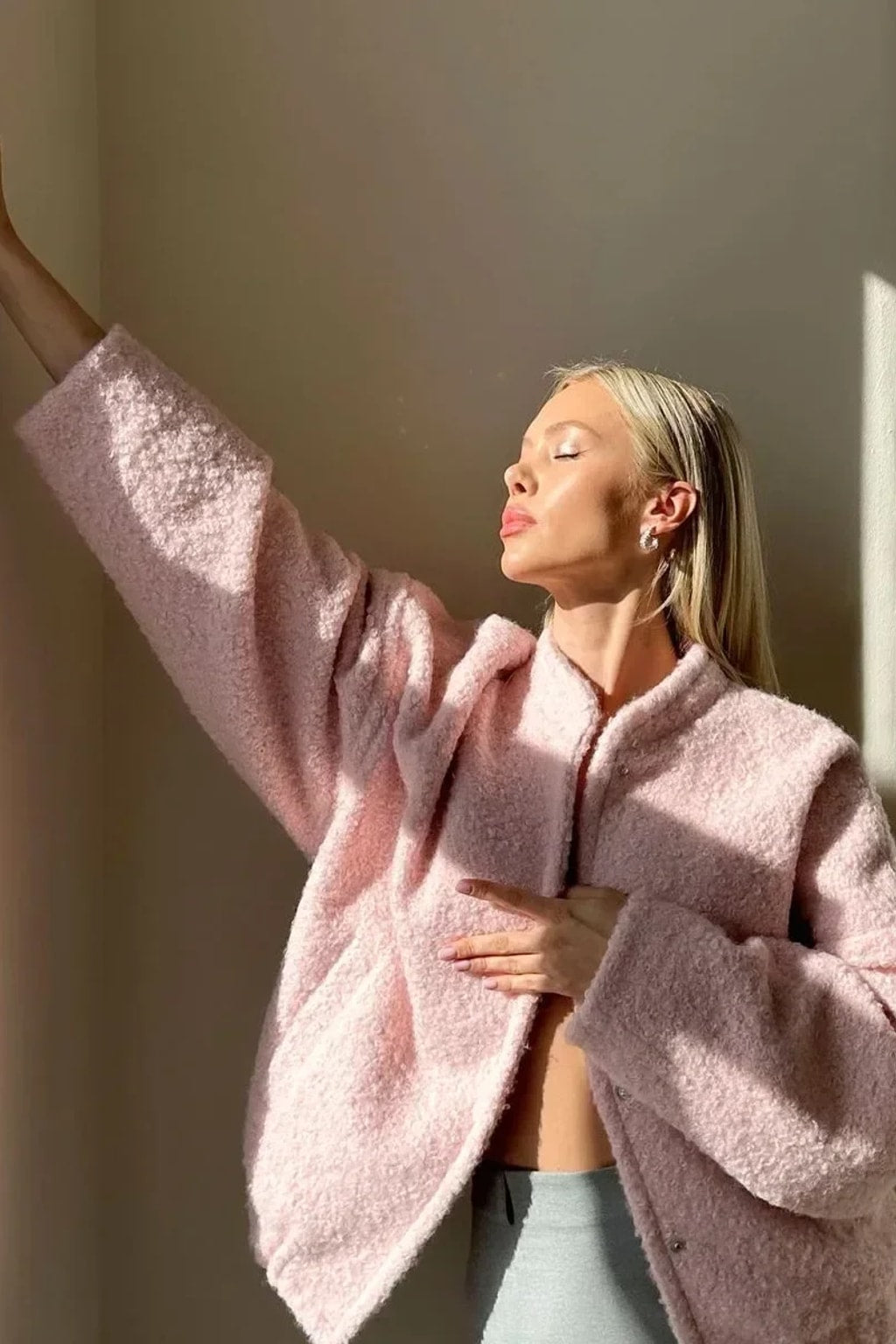 Pink boucle cropped bomber jacket with balloon sleeves, a collarless round neck and a snap front