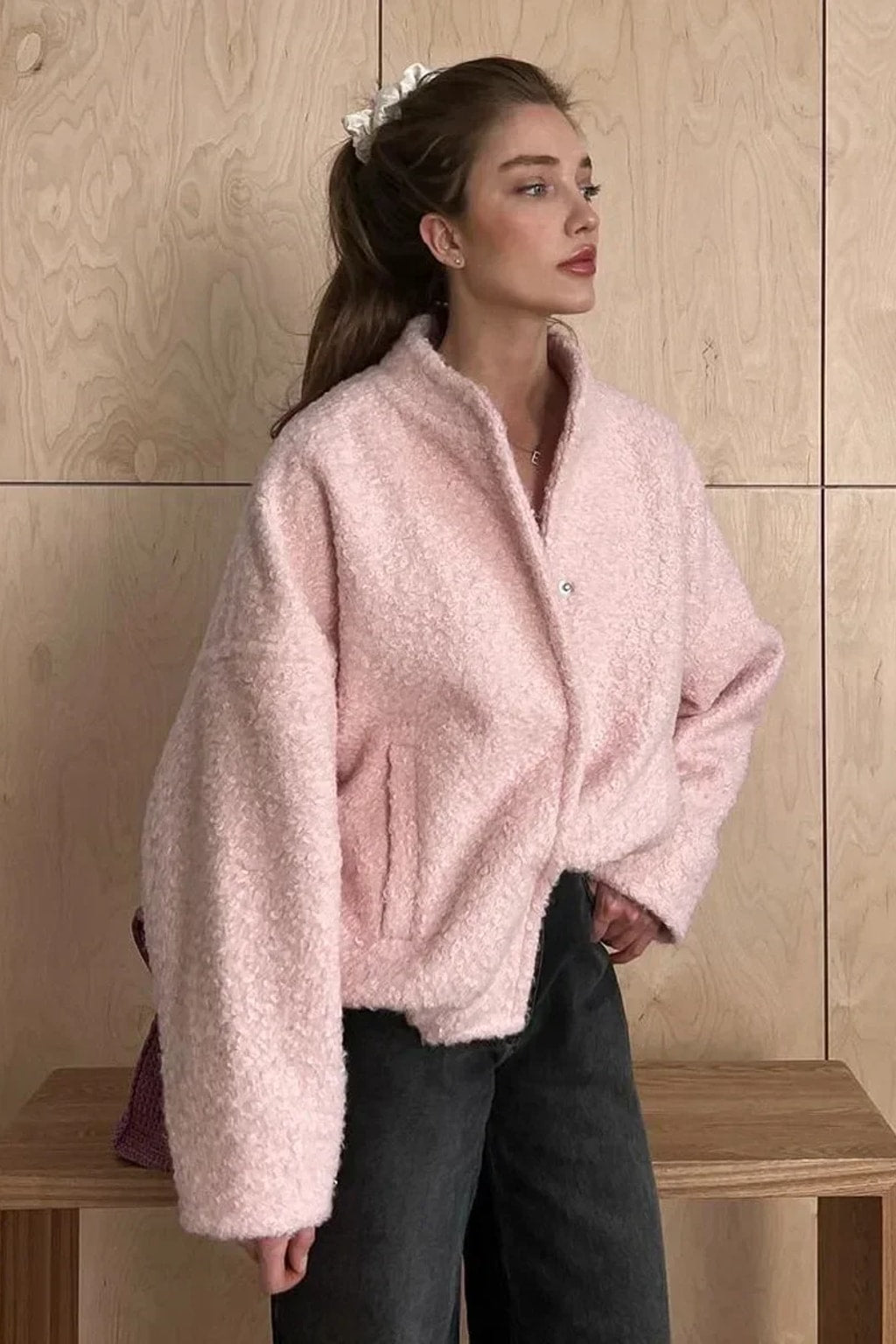 Pink boucle cropped bomber jacket with balloon sleeves, a collarless round neck and a snap front