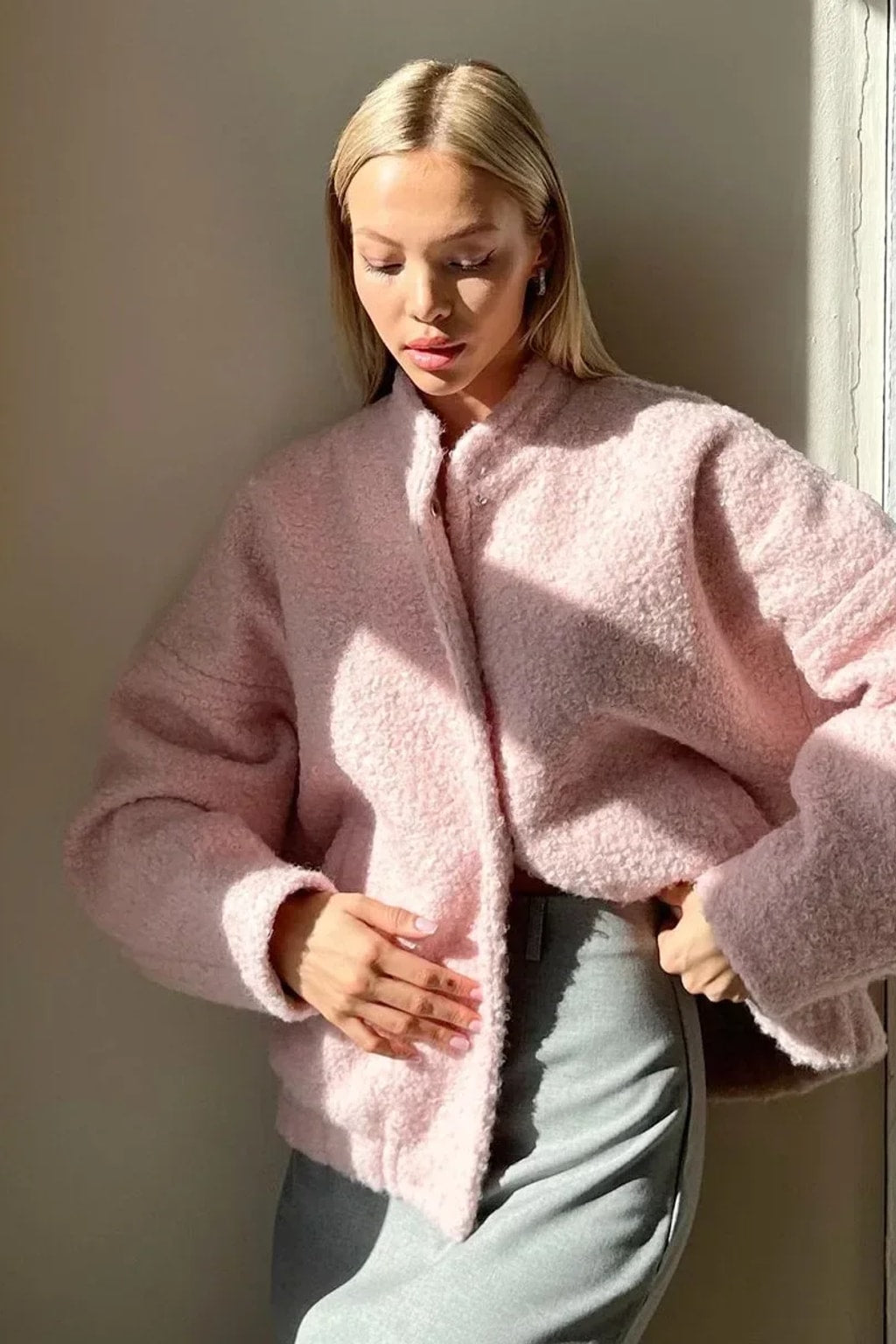 Pink boucle cropped bomber jacket with balloon sleeves, a collarless round neck and a snap front