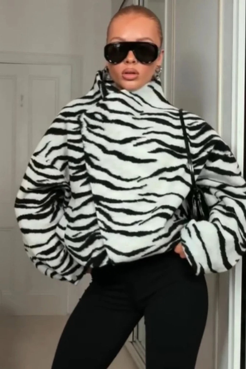 Black and white zebra print faux fur cropped jacket with an asymmetric wrap front and tall funnel collar