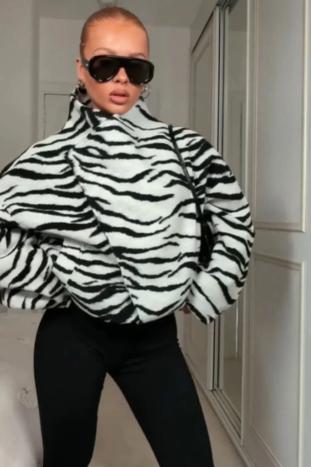 Black and white zebra print faux fur cropped jacket with an asymmetric wrap front and tall funnel collar