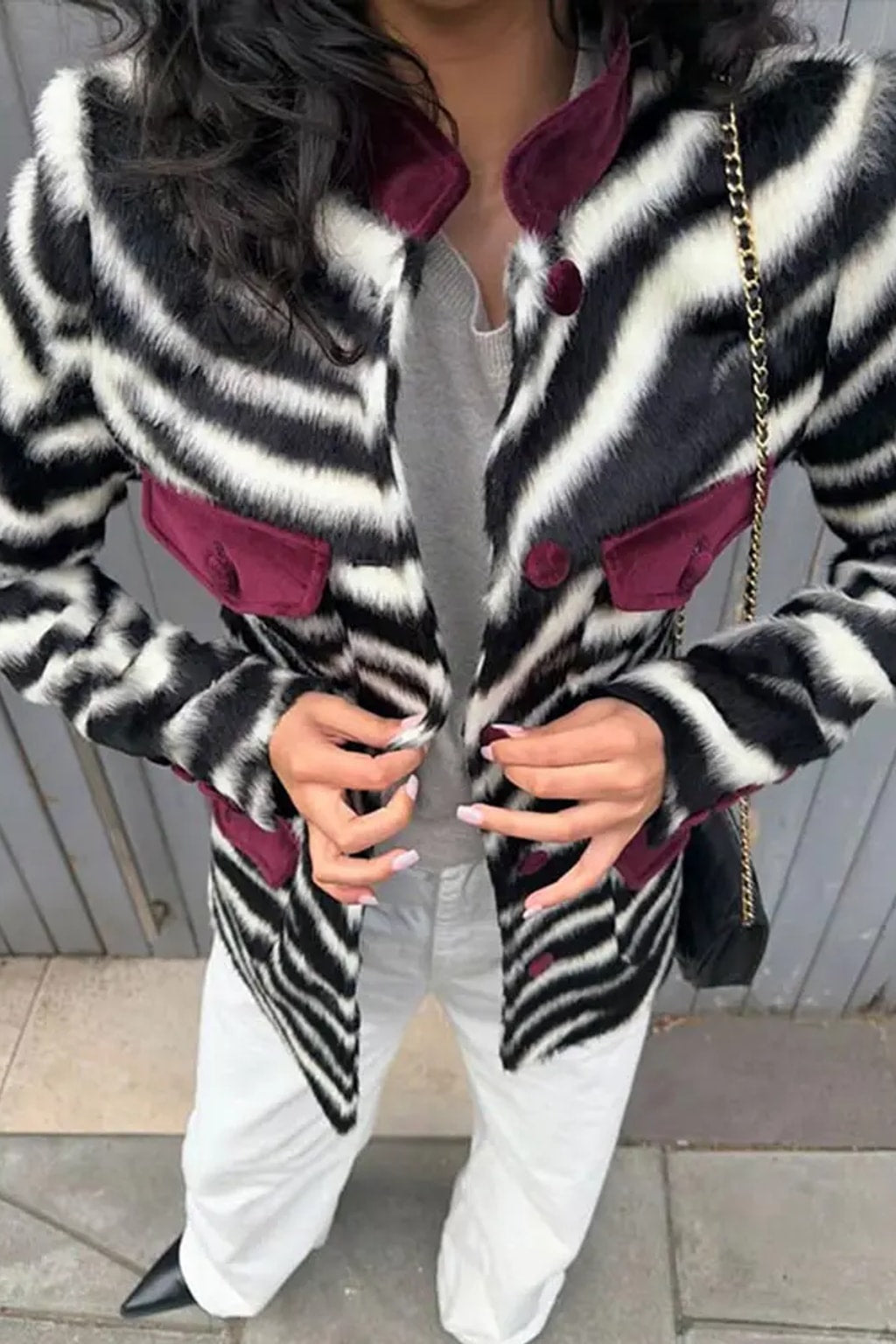 Fitted zebra print faux fur jacket with burgundy velvet stand collar, flap pockets and covered buttons