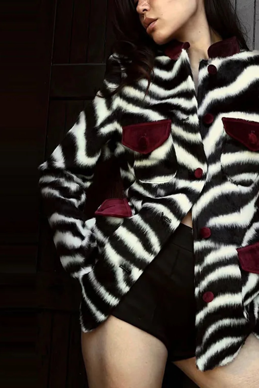 Fitted zebra print faux fur jacket with burgundy velvet stand collar, flap pockets and covered buttons