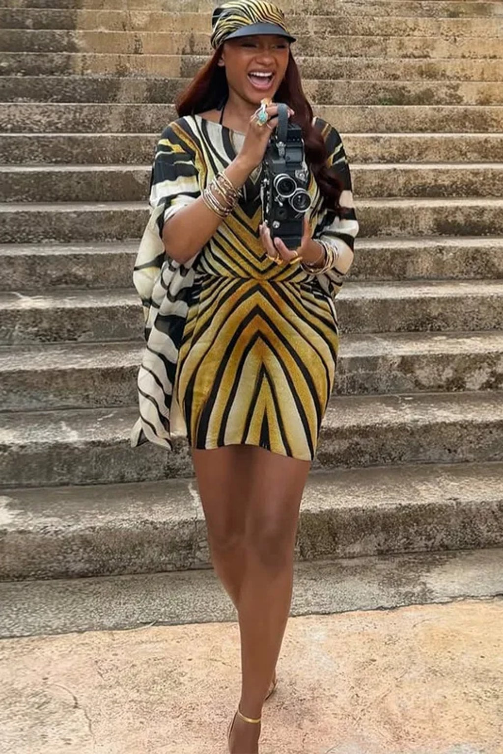 Chiffon kaftan mini dress in a radiating black, cream and gold tiger stripe with wide cape sleeves and a front tie sash